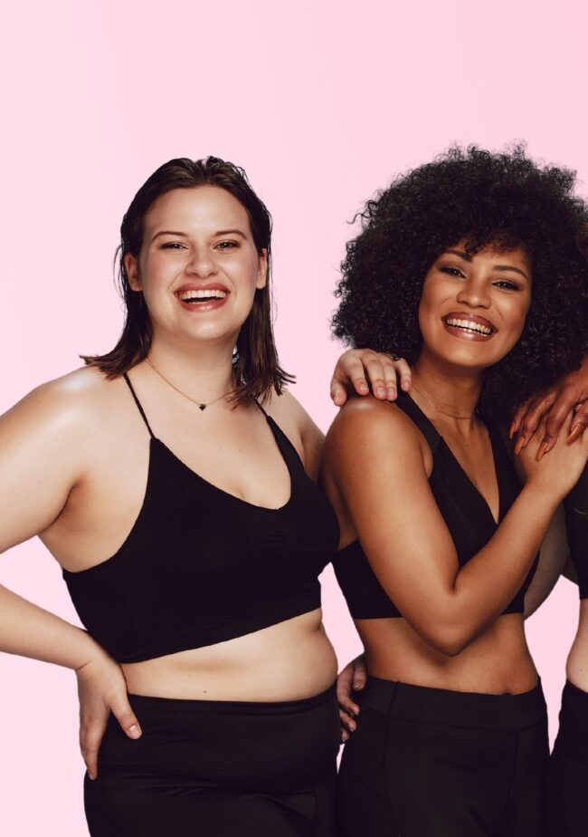 Mulheres de diferentes corpos sorridentes em roupa de treino